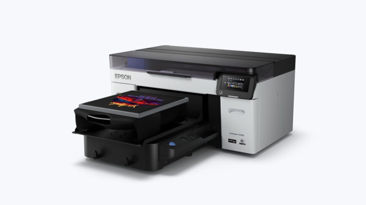A digital printer printing a design on a black T-shirt